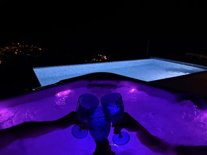 Jacuzzi e piscina iluminados à noite
