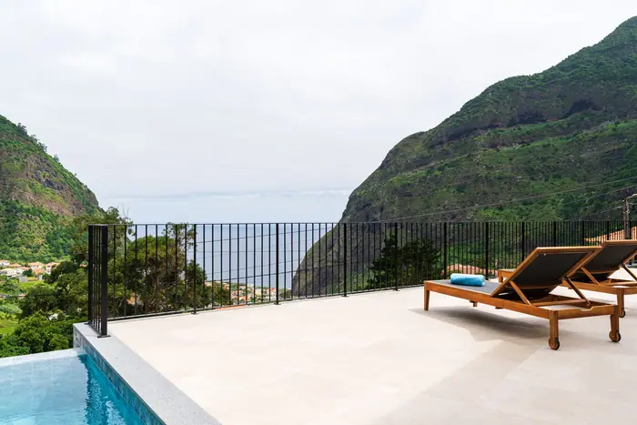 Espreguiçadeiras no terraço da piscina com vista para o oceano