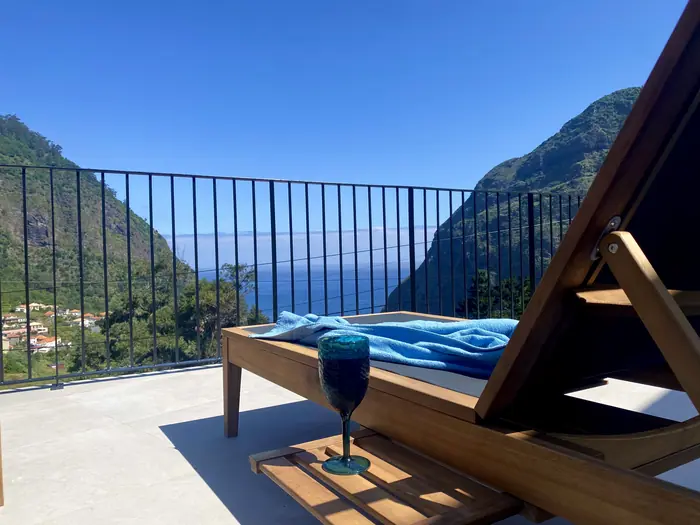 Espreguiçadeiras no terraço da piscina com vista para o oceano