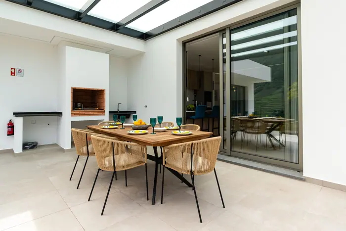 Terraço coberto com mesa de refeições e vista para a serra