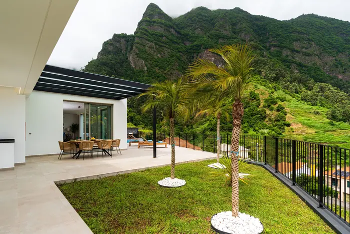 Terraço, relvado e palmeiras aos pés da serra