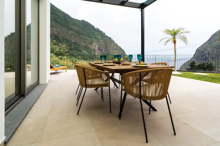 Terraço coberto com mesa de refeições e vista para a serra