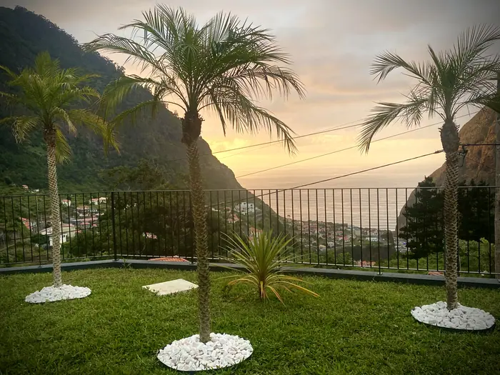 Pôr do sol sobre o mar visto do jardim com palmeiras